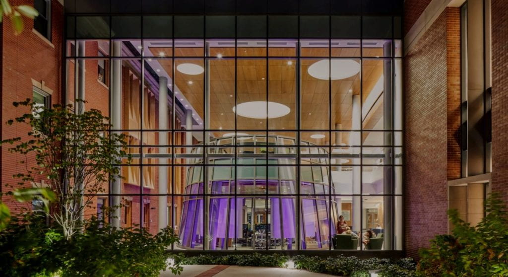 looking through the glass windows into the interior of the School of Business building